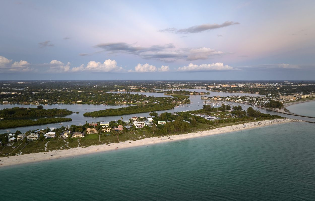 Nokomis beach with soft white sand in Sarasota county, USA. Many people enjoing vacation time bathing in warm gulf water and tanning under hot Florida sun at sunset.